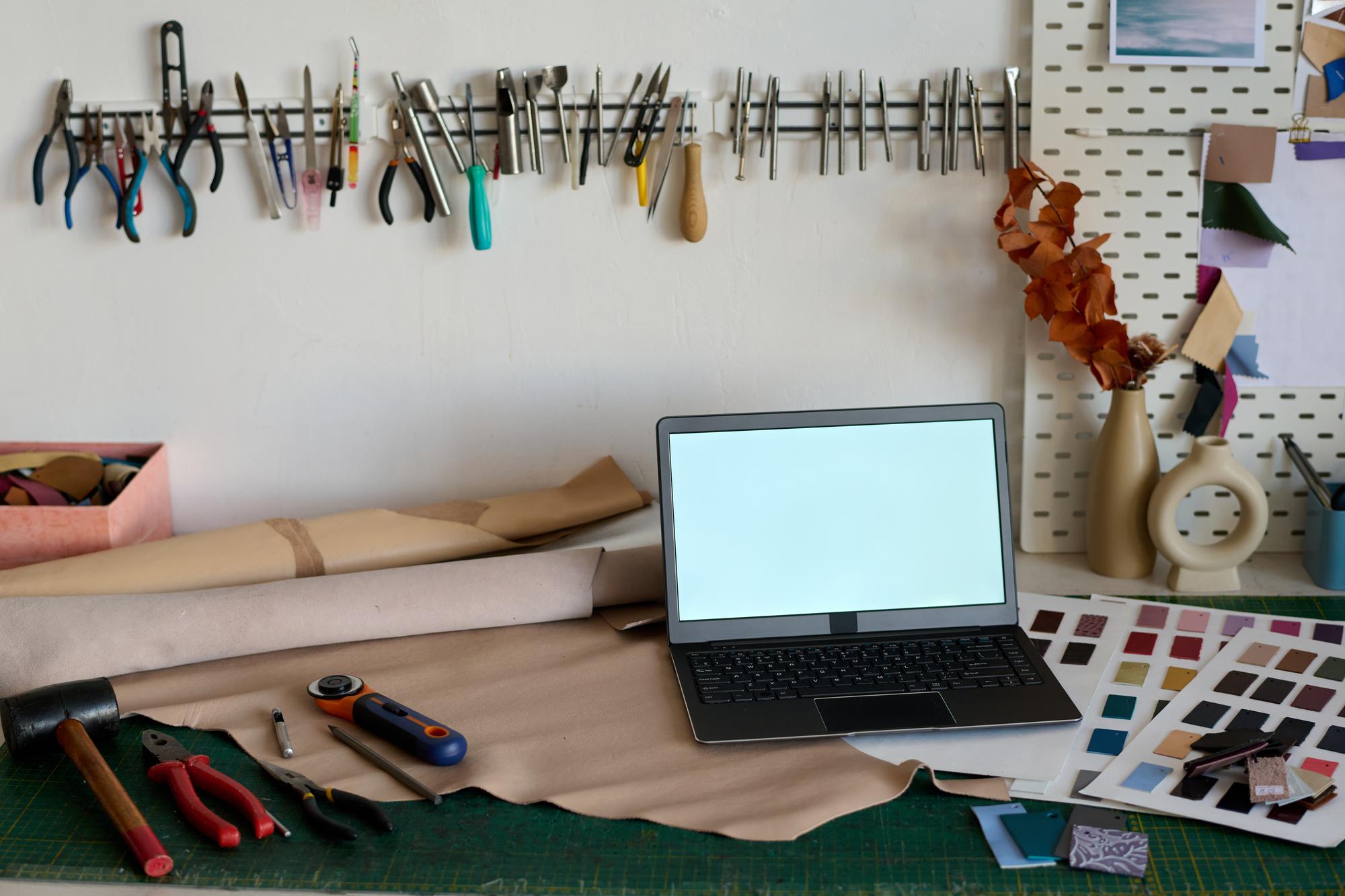 Setup workspace con macchina da ricamo e laptop